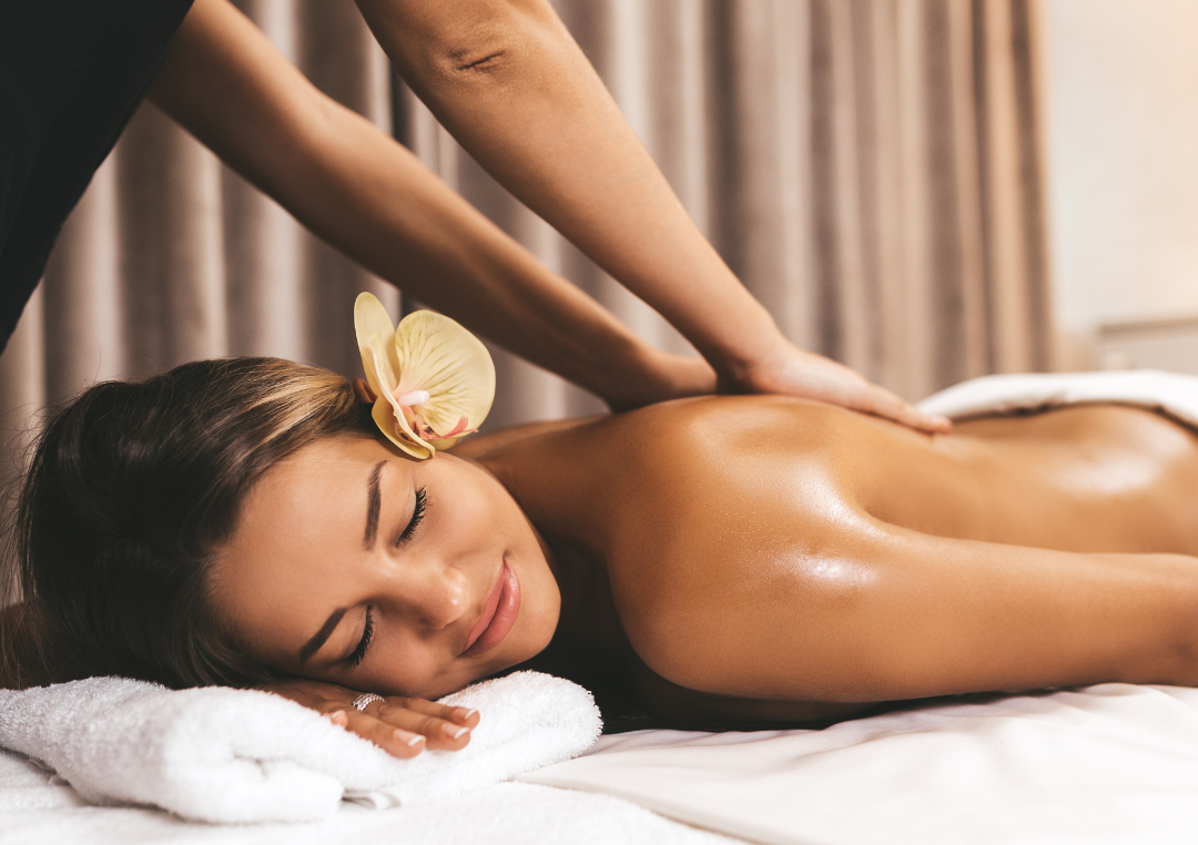Woman receiving a relaxing full-body massage with an orchid in her hair at DaVida med spa in San Antonio