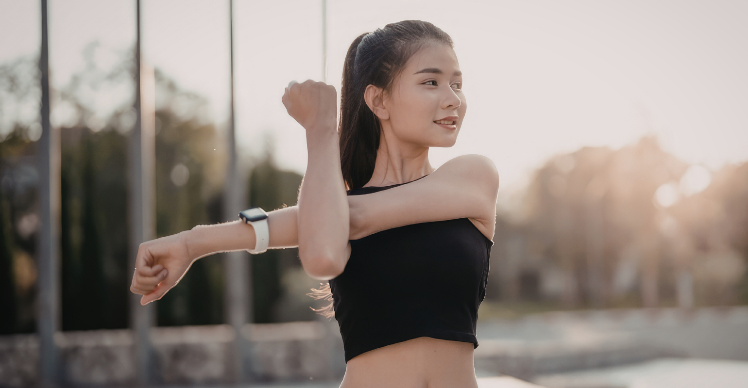 Woman stretching at sunrise, reflecting the energy and vitality of peptide therapy in San Antonio