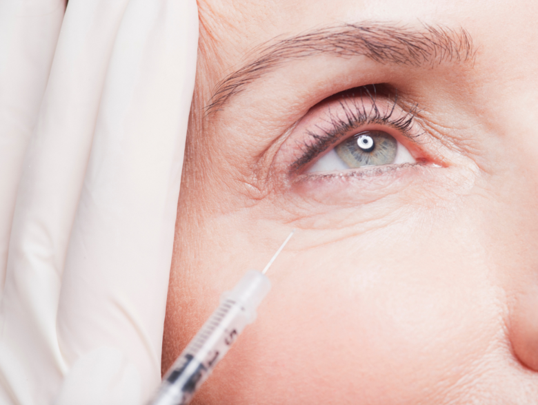 Provider injecting under-eye filler into a client's tear trough with a cannula